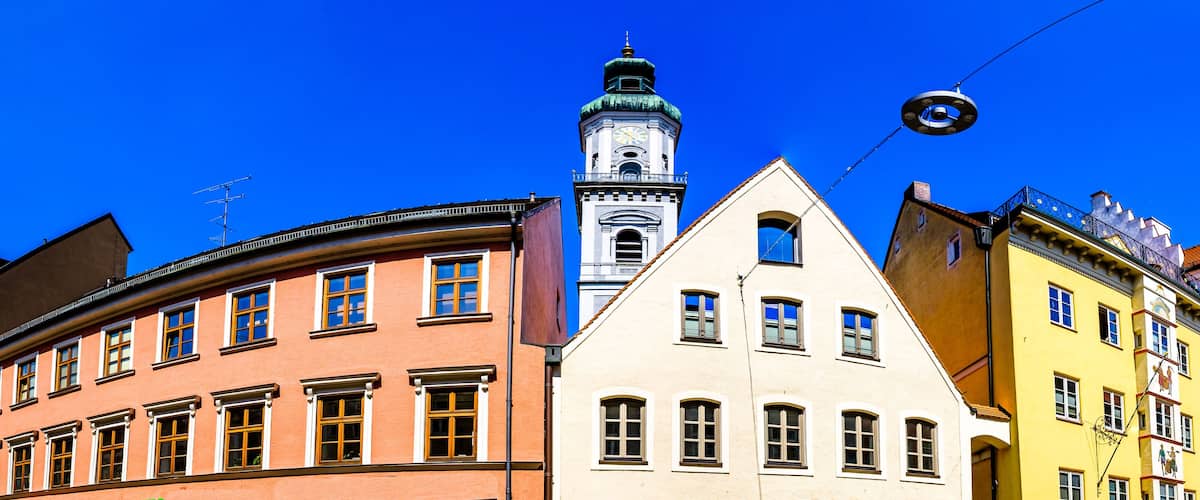 A row of colorful buildings with a prominent clock tower in the background.
