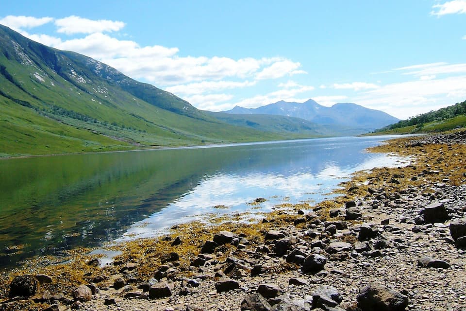 Un llac tranquil envoltat de muntanyes i vores rocoses.