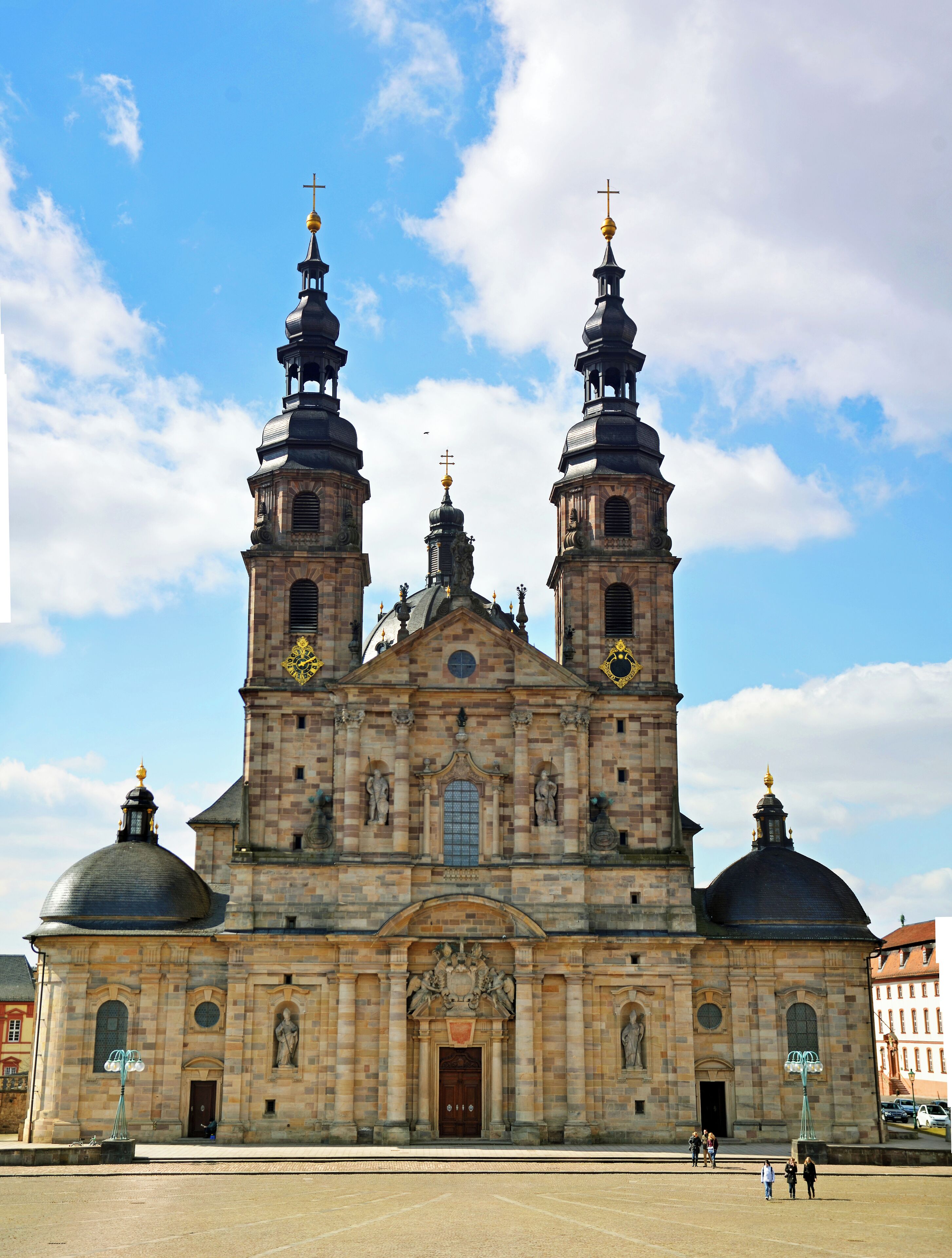 A historic church with two tall towers and domes, featuring ornate stonework and golden crosses.