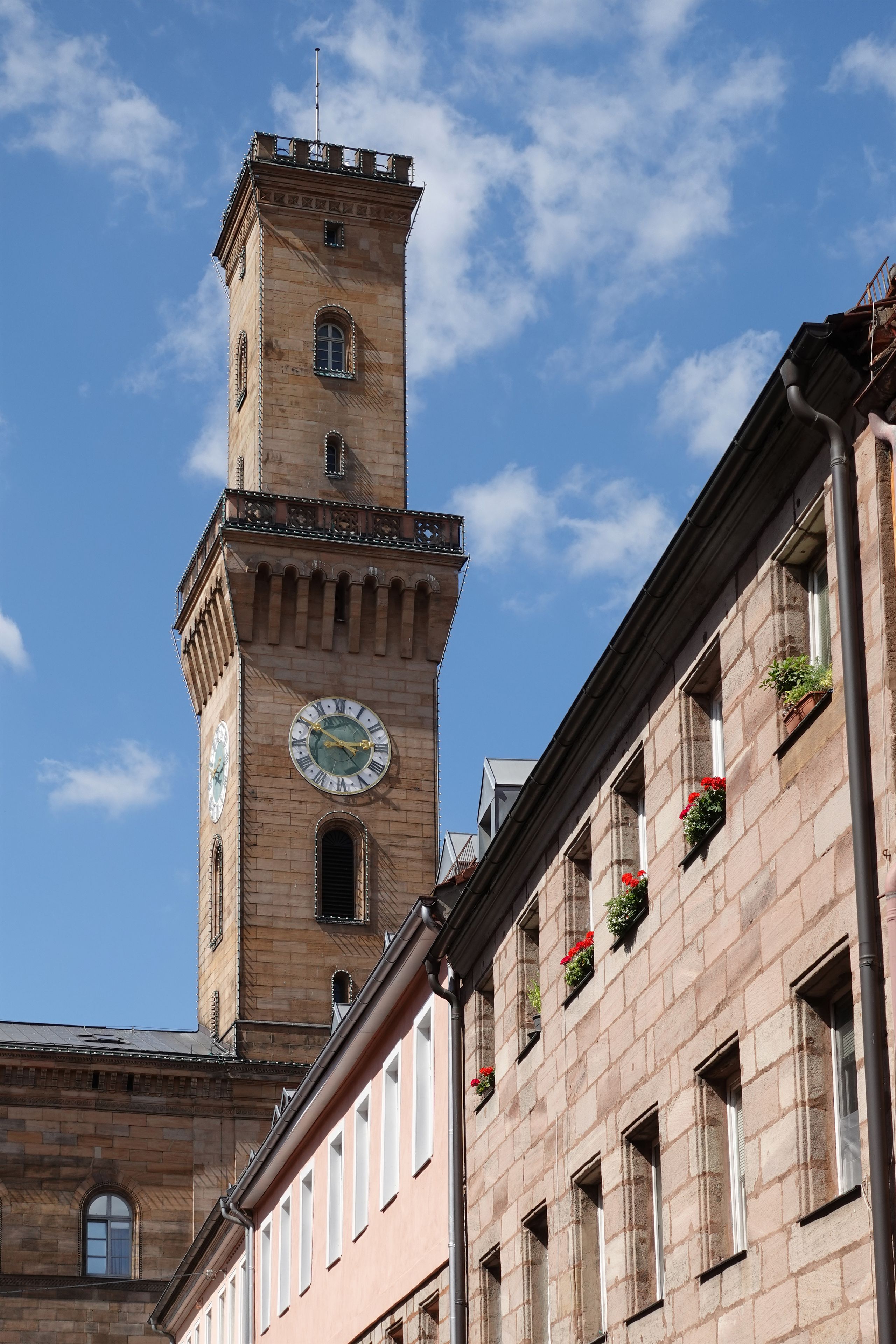 Ein historisches Gebäude mit einem Glockenturm, gebogenem Fensterbogen und einer Ziegel-Fassade.