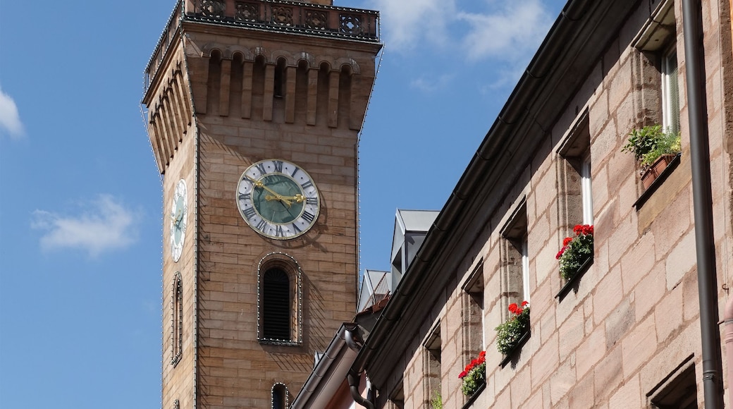 Ein historisches Gebäude mit einem Glockenturm, gebogenem Fensterbogen und einer Ziegel-Fassade.