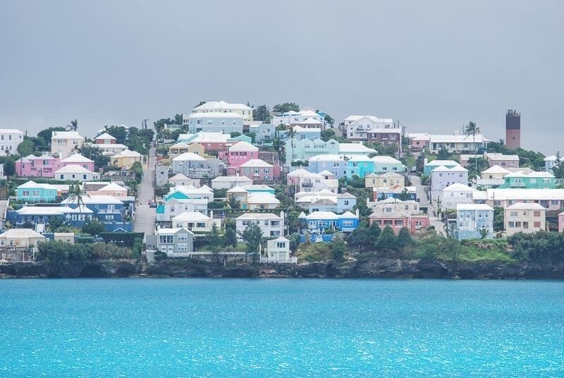 A coastal town with colorful houses and a prominent tower.