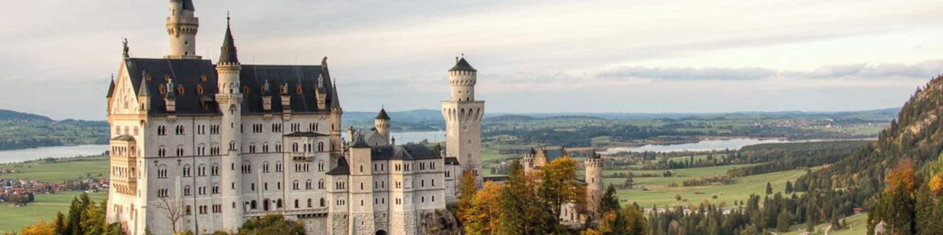A castle surrounded by forest and hills.