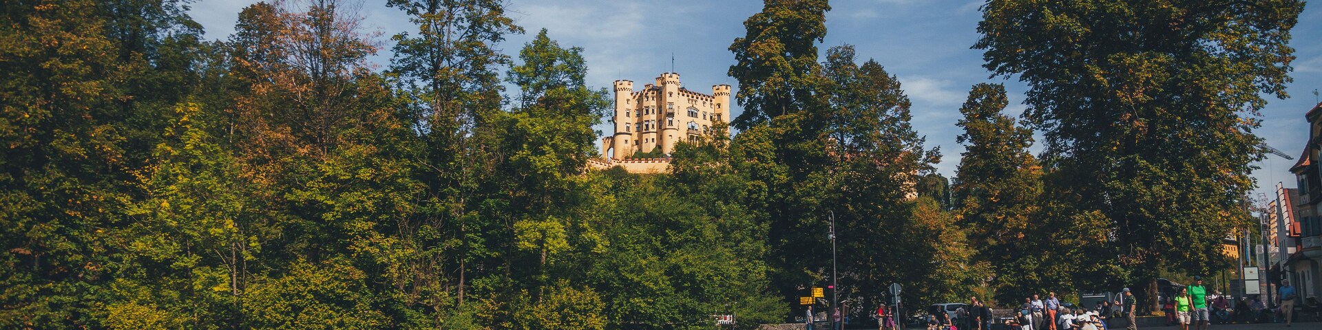 Un parco con un castello sullo sfondo, un sentiero curvo e una distesa d'acqua.