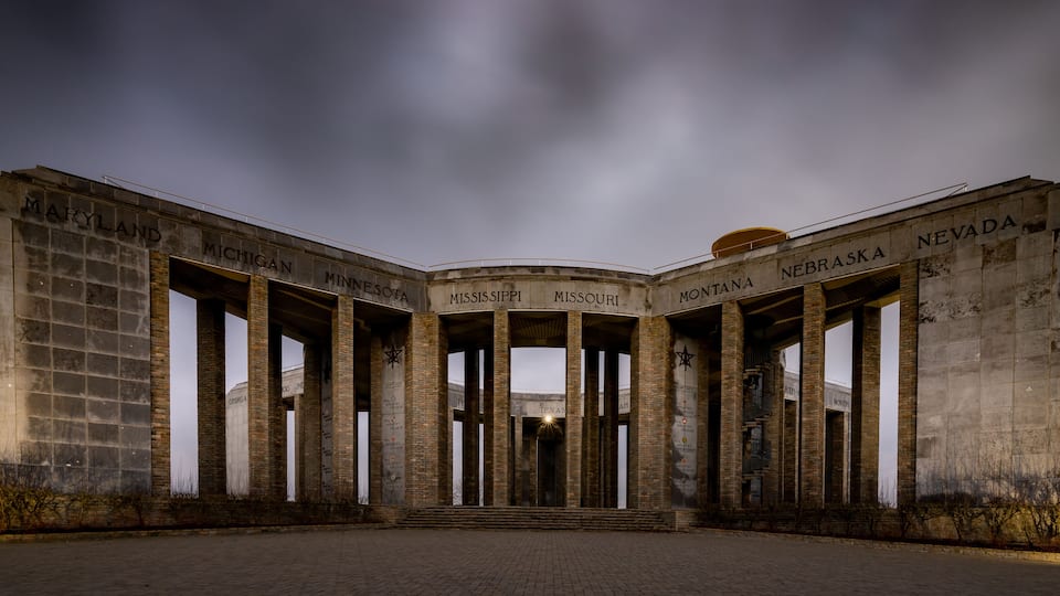 A large, historic building with columns labeled with state names like Maryland, Michigan, and Nevada.
