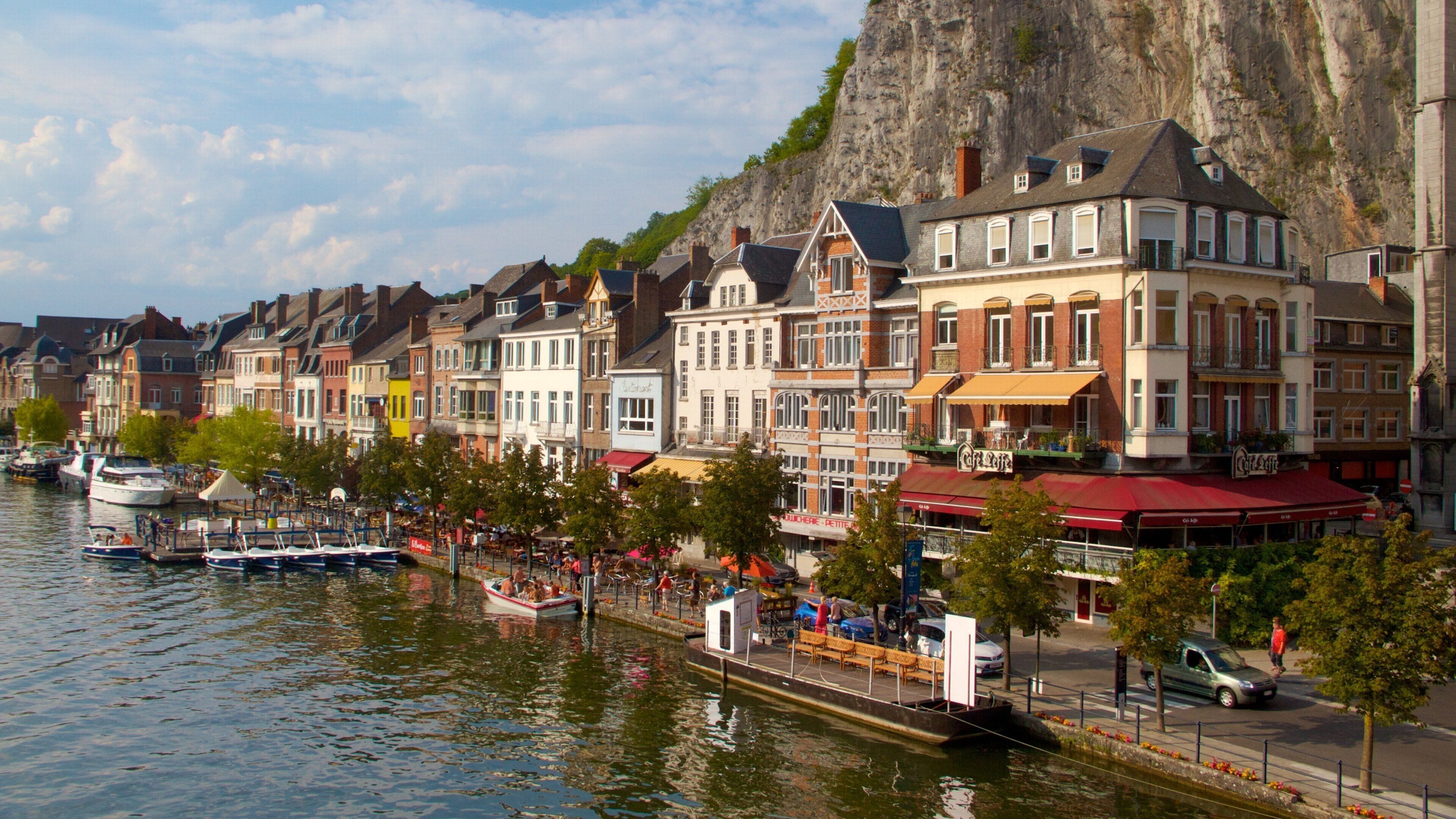 A riverside town with historic buildings, a café, and boats.