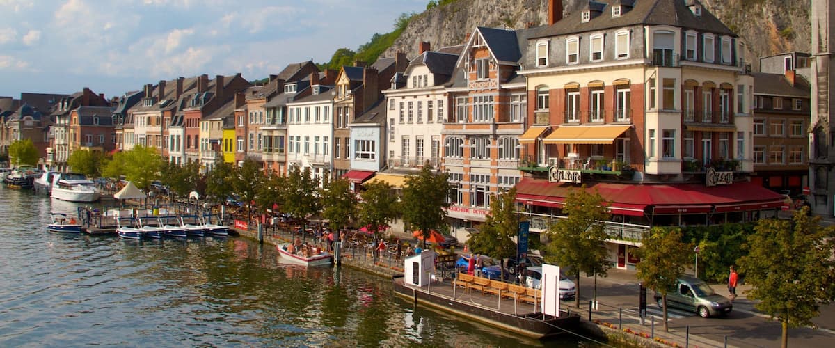 A riverside town with historic buildings, a café, and boats.