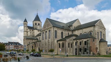 Una iglesia histórica con una torre destacada y varios ventanales de arco.