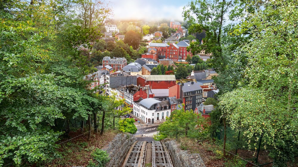 Eine Stadt mit roten und weißen Gebäuden, umgeben von dichtem Grün.