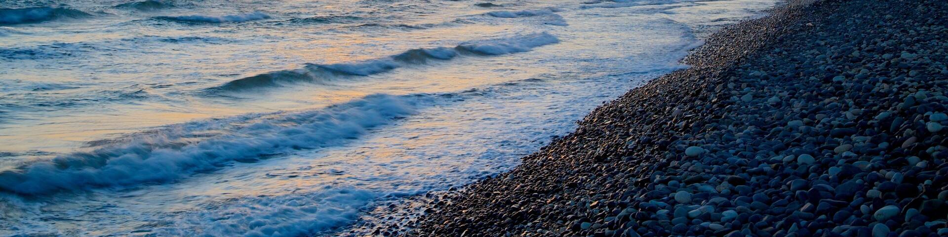 Limassol featuring a pebble beach and a sunset