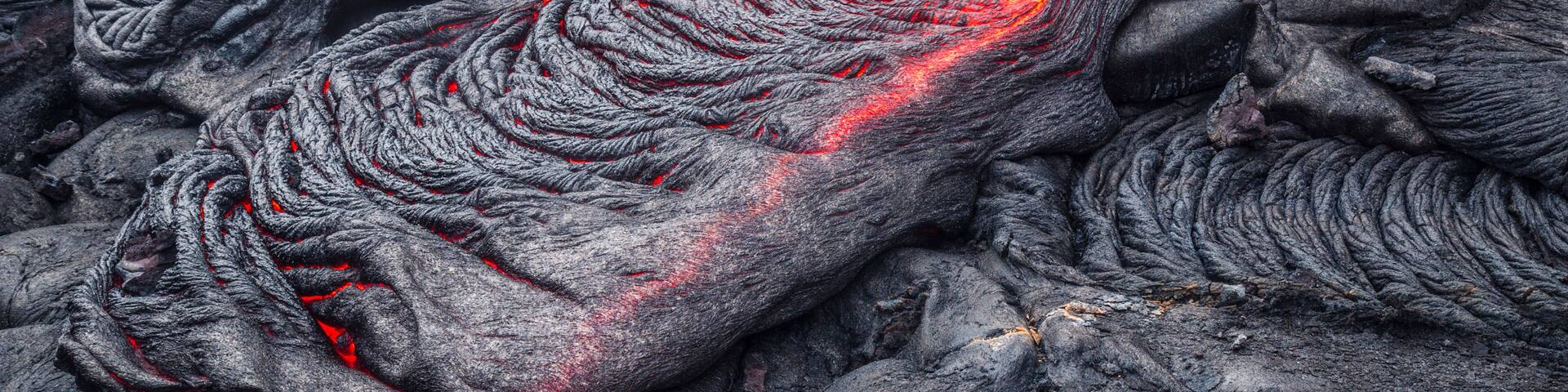 A close-up of flowing lava with bright orange and red hues.