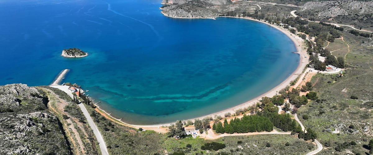 Aerial drone photo of paradise scenic round sandy beach of Karathonas next to historic city of Nafplio, Argolida, Greece