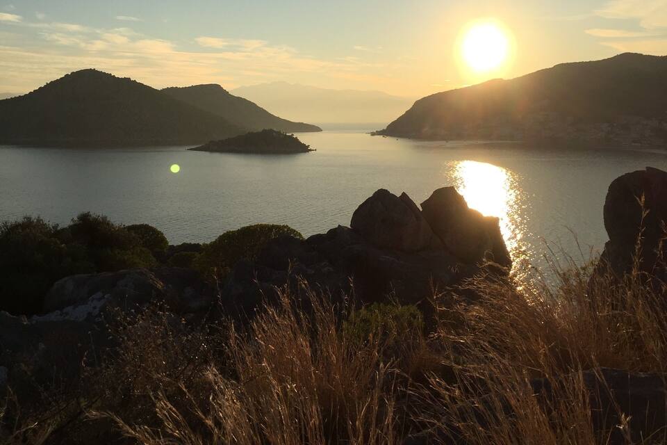 A sunset over a calm lake with mountains in the background.