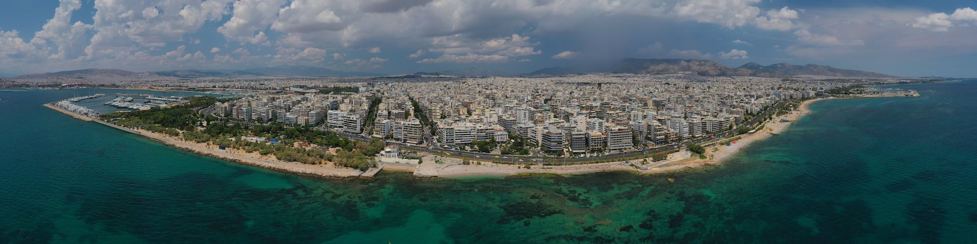 Aerial panoramic photo of famous seaside bay of Faliro with beautiful emerald sea, clouds and deep blue sky