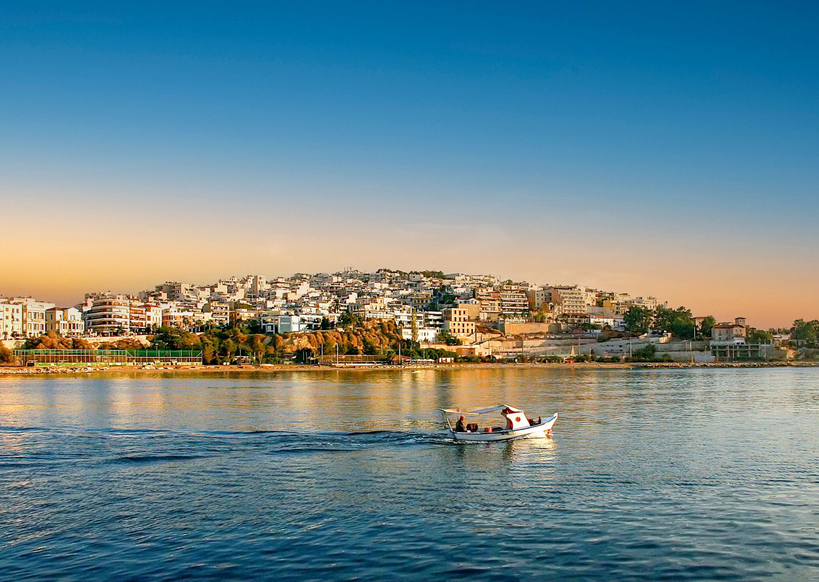 Fisherman go for fishing with a small wooden boat at sunrise. Pasalimani, Kastela, marina Zeas, in Piraeus port, Greece.