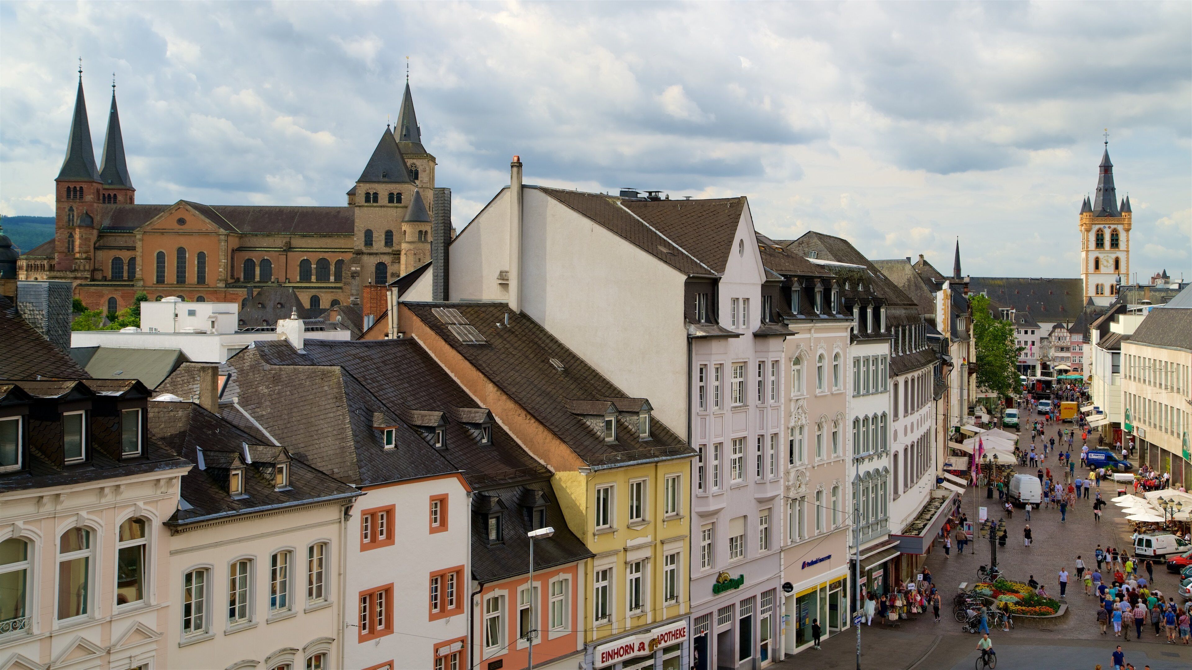 A historic European town with colorful buildings, a prominent church, and a bustling market square.