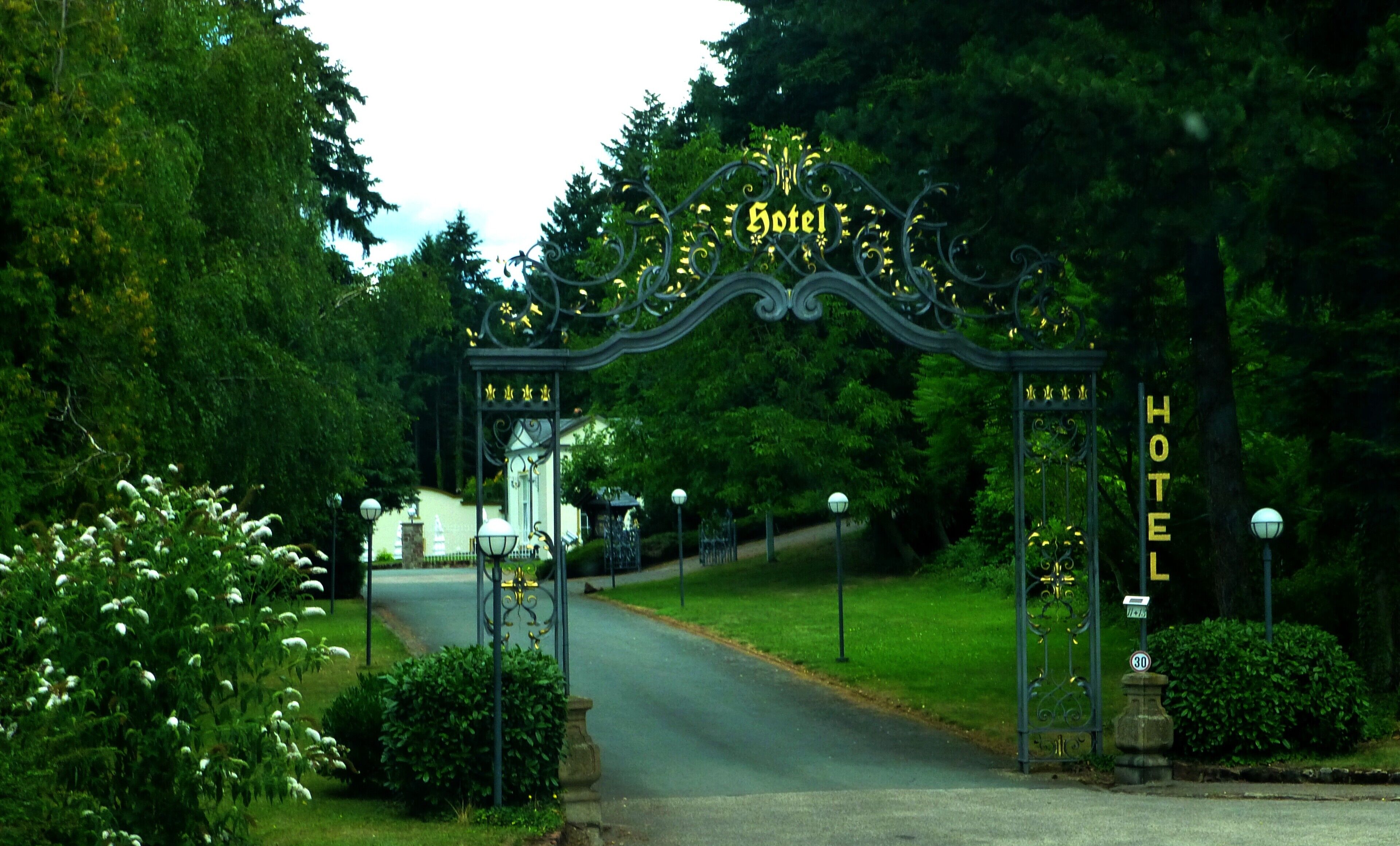A hotel entrance with ornate metal gates and a sign.