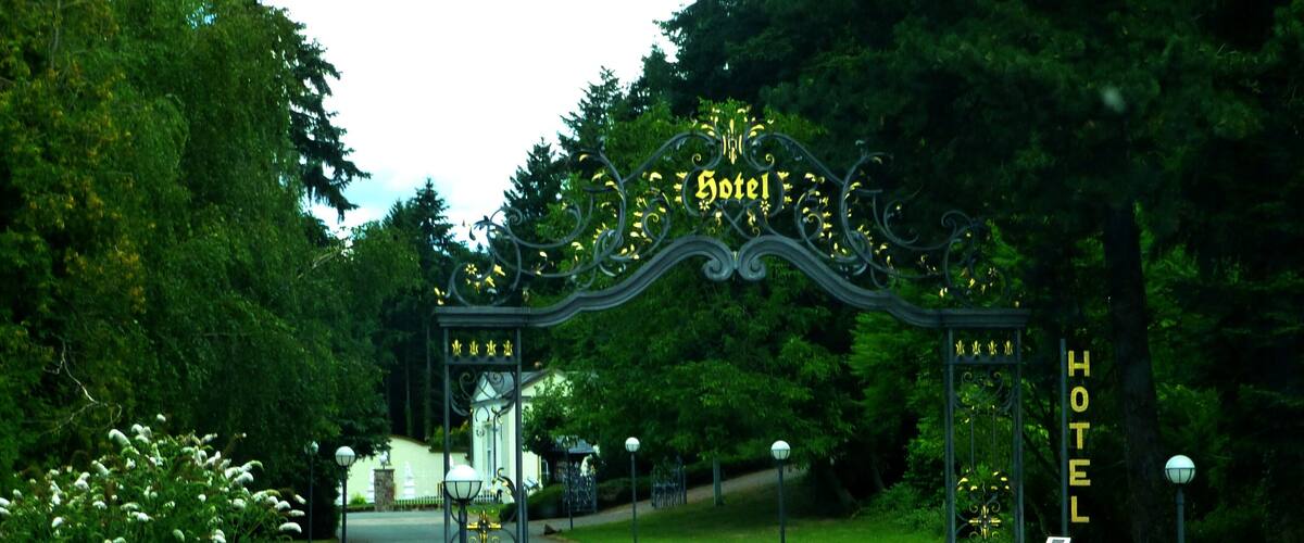 A hotel entrance with ornate metal gates and a sign.
