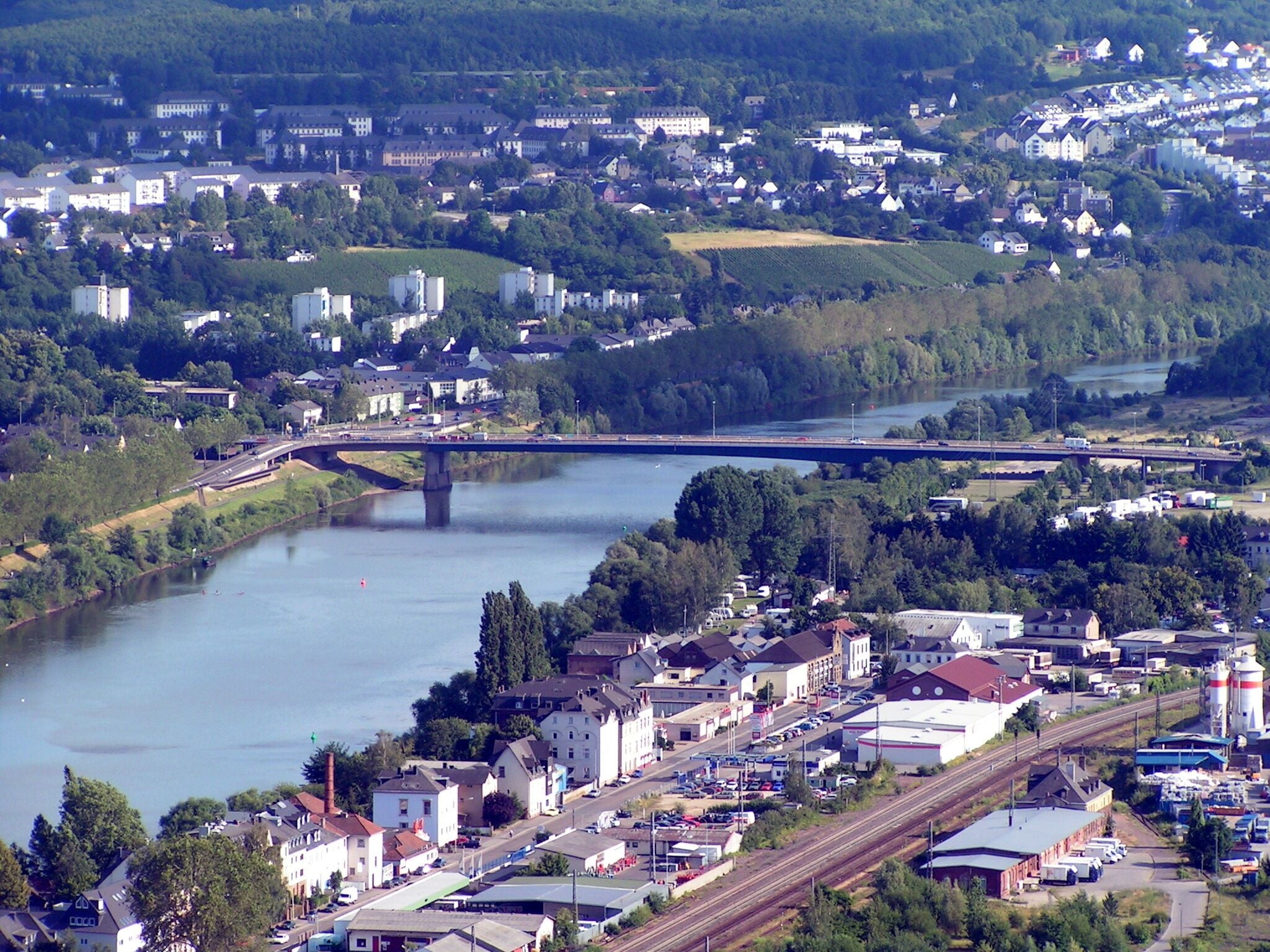 A river with a bridge, a town with buildings, and a railway line.