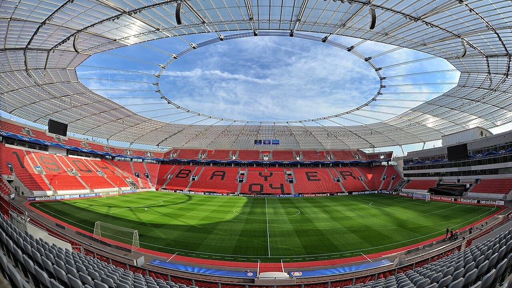 Ein großes Stadion mit gewölbtem Dach und einem grünen Spielfeld.