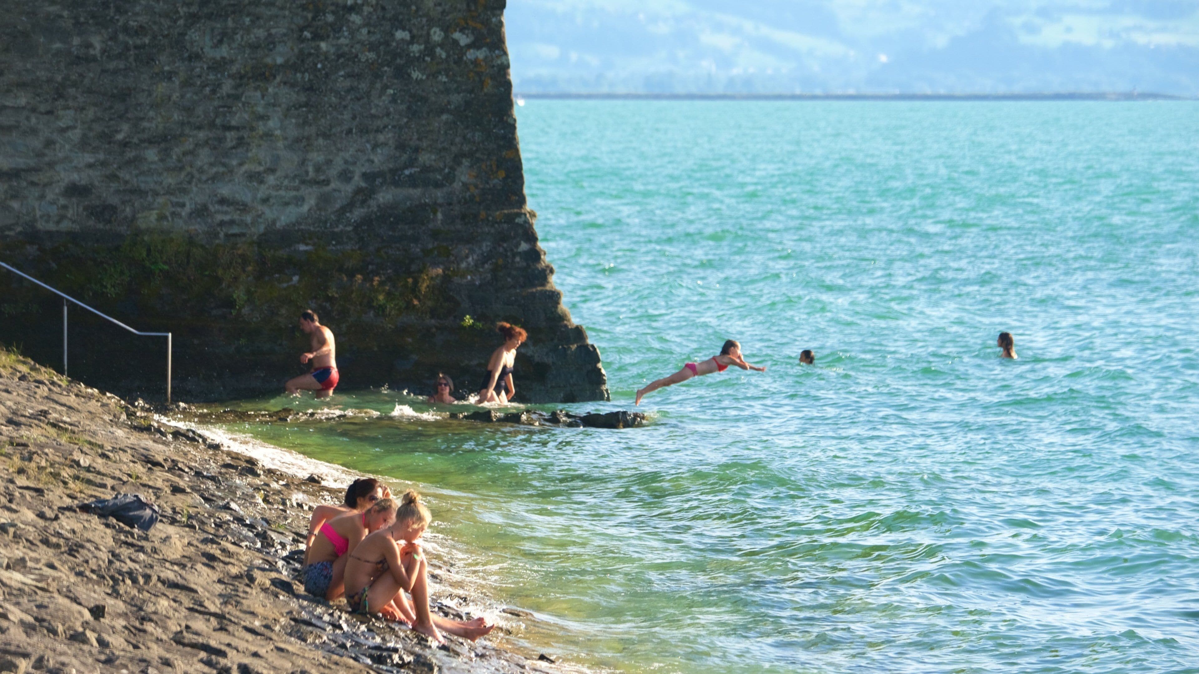 Lindau mostrando litoral rochoso assim como um pequeno grupo de pessoas