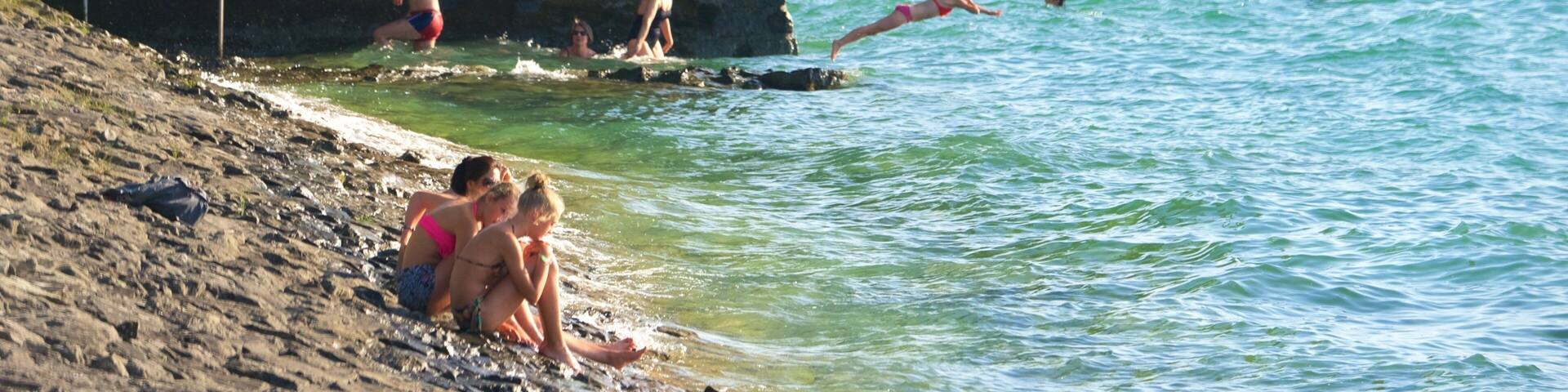 Lindau which includes rocky coastline as well as a small group of people