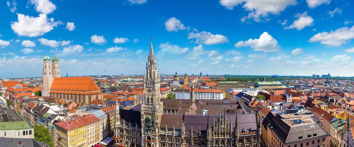 A historic cityscape with prominent Gothic architecture, including a tall spire and a clock tower.
