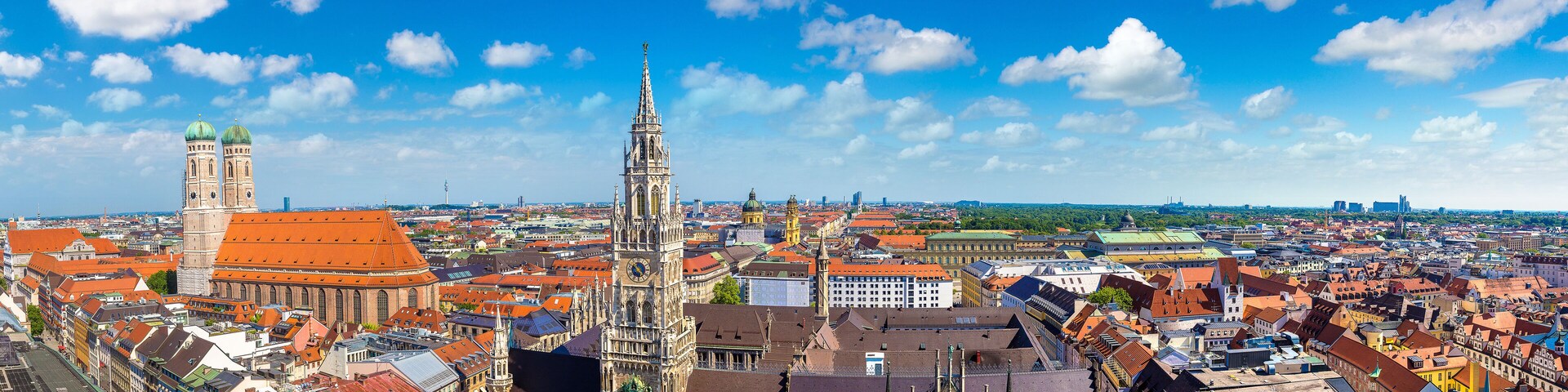 A historic cityscape with prominent Gothic architecture, including a tall spire and a clock tower.