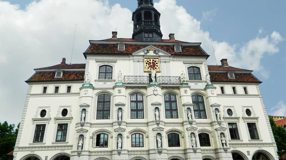Ein historisches Gebäude mit einem Glockenturm, Rundbogenfenstern und Statuen.
