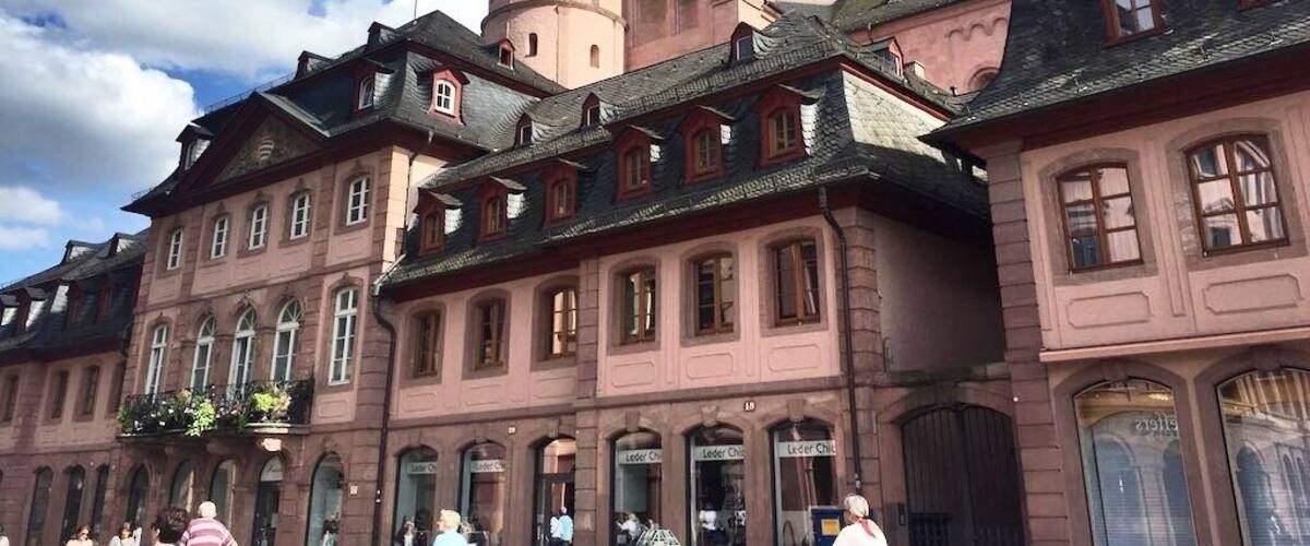 Mainz is a German city on the Rhine River. It’s known for its old town, with half-timbered houses and medieval market squares. In the center, the Marktbrunnen is a Renaissance fountain with red columns. Nearby, a distinctive octagonal tower tops the Romanesque Mainz Cathedral, built of deep red sandstone. The Gutenberg Museum honors the inventor of the printing press with exhibits, including 2 of his original bibles.