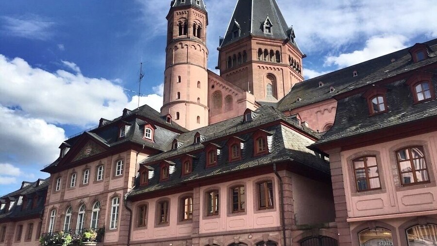 Mainz is a German city on the Rhine River. It’s known for its old town, with half-timbered houses and medieval market squares. In the center, the Marktbrunnen is a Renaissance fountain with red columns. Nearby, a distinctive octagonal tower tops the Romanesque Mainz Cathedral, built of deep red sandstone. The Gutenberg Museum honors the inventor of the printing press with exhibits, including 2 of his original bibles.