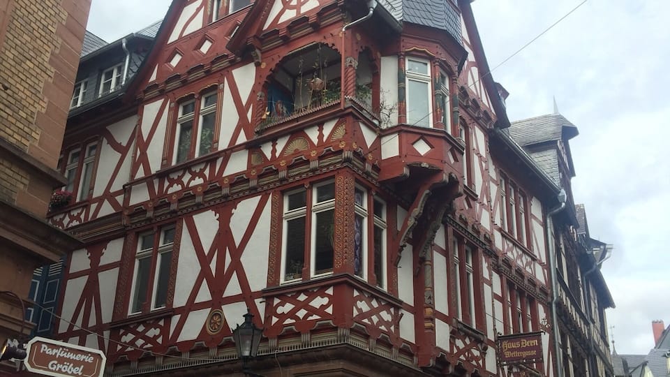 Ein traditionelles Fachwerkhäuschen mit einem markanten Turm und einem Schild mit der Aufschrift "HUSSEL".