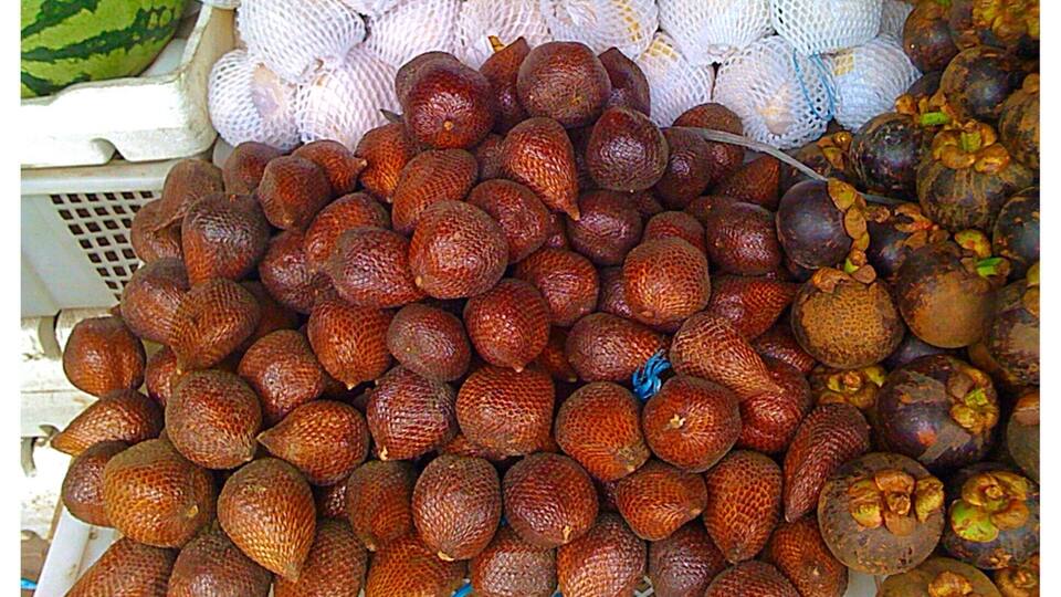 I can never get enough eating Snake Fruit when I travel to Indonesia.
Snake fruit, more technically known as salak or salacca zalacca, is native to Indonesia but is now grown and produced around southeast Asia. The fruit grows on the salak palm tree, sprouting off the base of the palm in little clusters. The outside of the fruit is scaly like a snake and prickly like a cactus, but the inside is sweeter than honey, sour like a pineapple and incredibly juicy. Its flesh is slightly acidic, giving your tongue a citrus like tingle. Yummm...