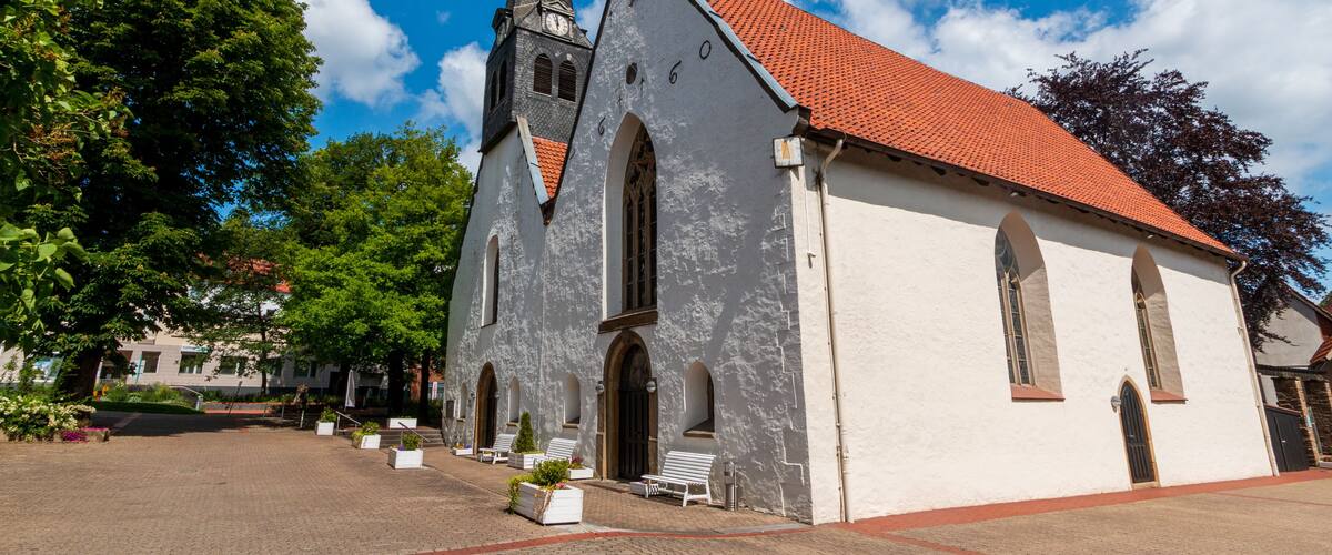 A church with a tall steeple and a red-tiled roof.