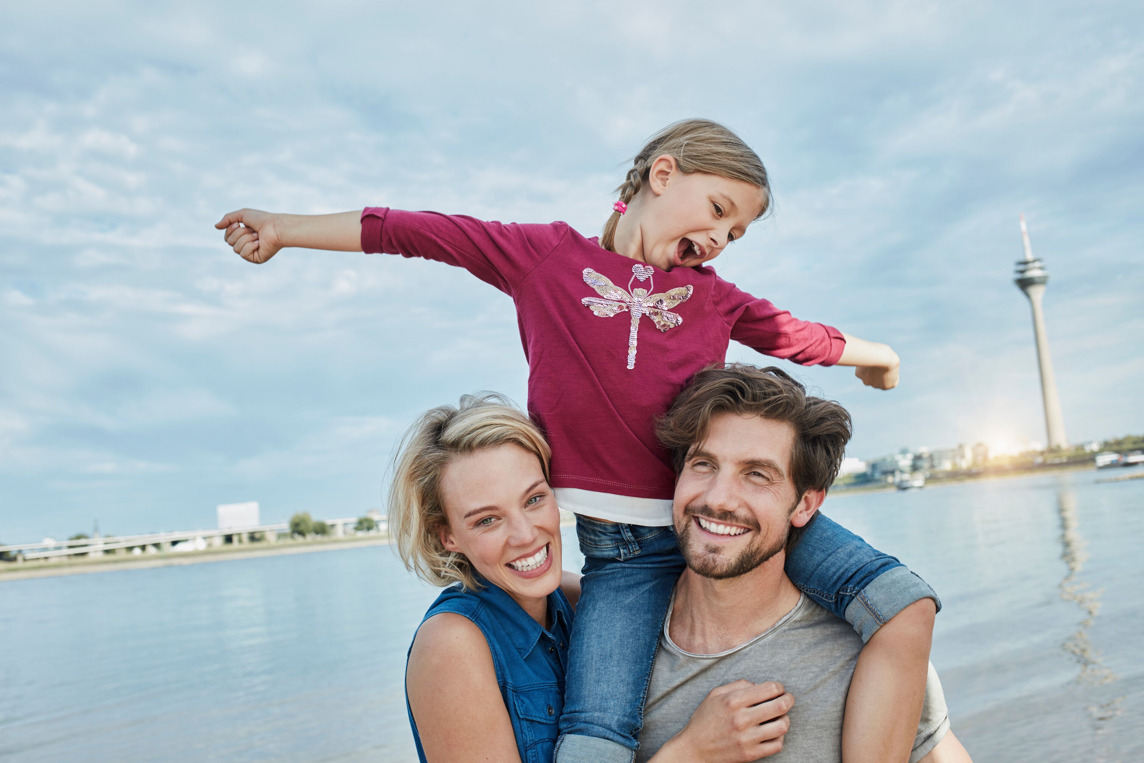 Germany, Duesseldorf, happy family with daughter at Rhine riverbank