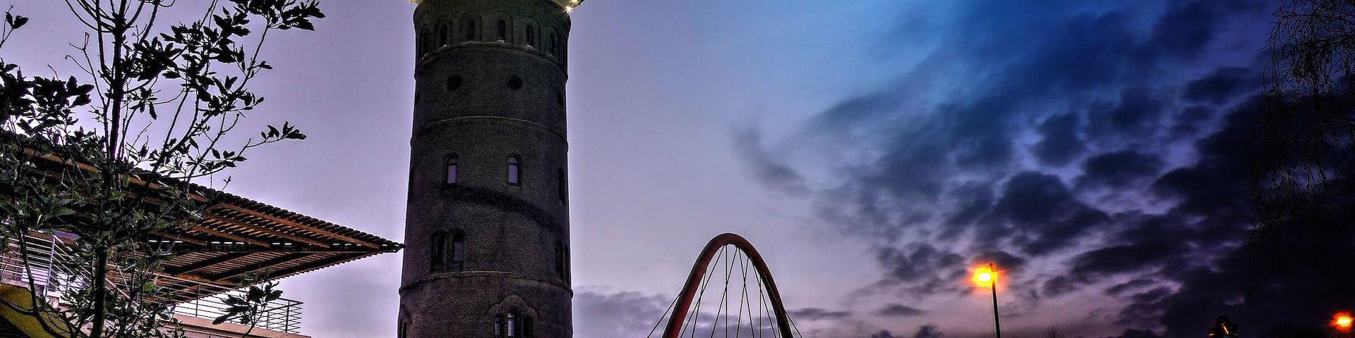 A water tower, a bridge, and a roller coaster at dusk.