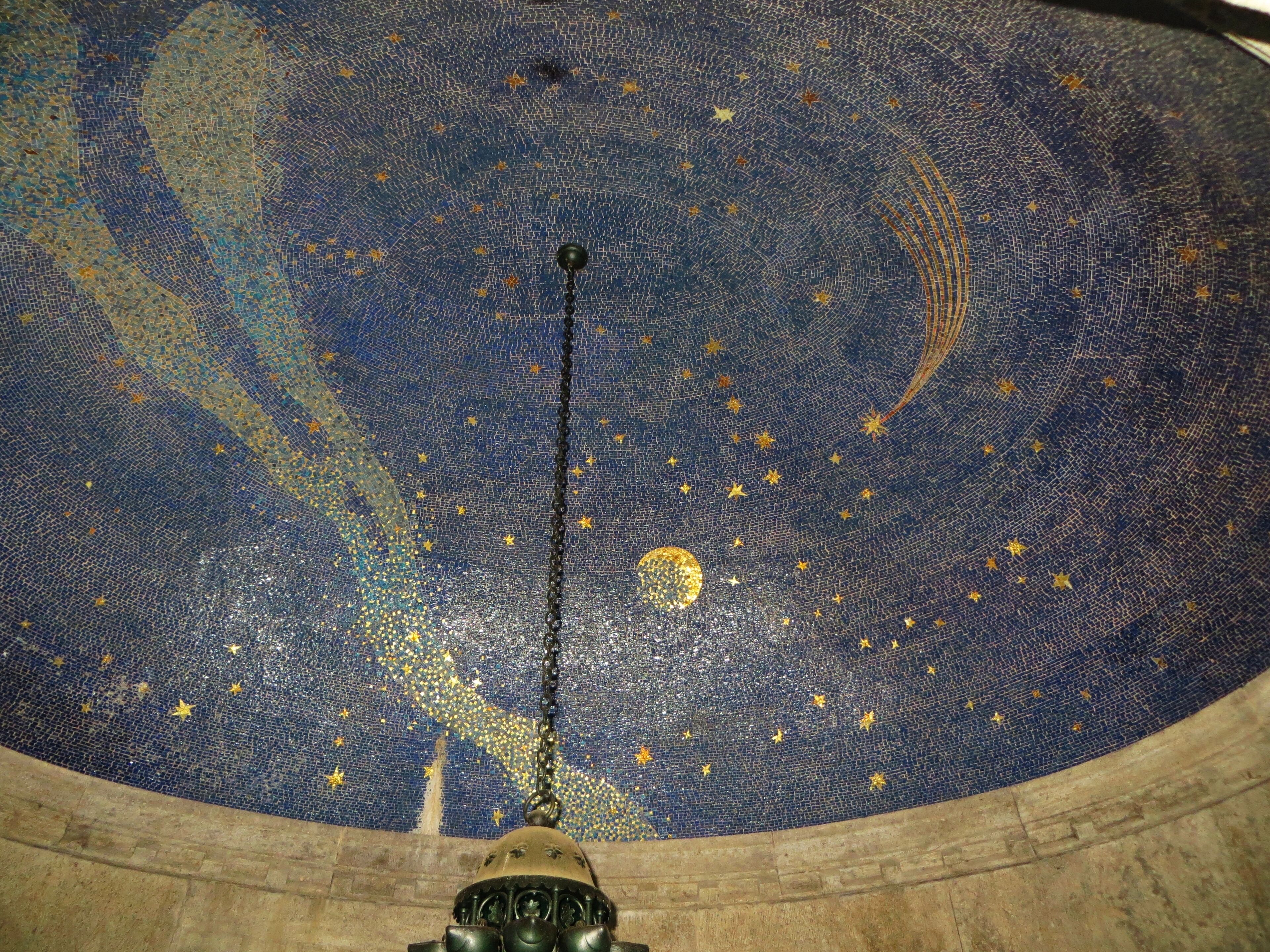 A starry mosaic ceiling with a central hanging light fixture.