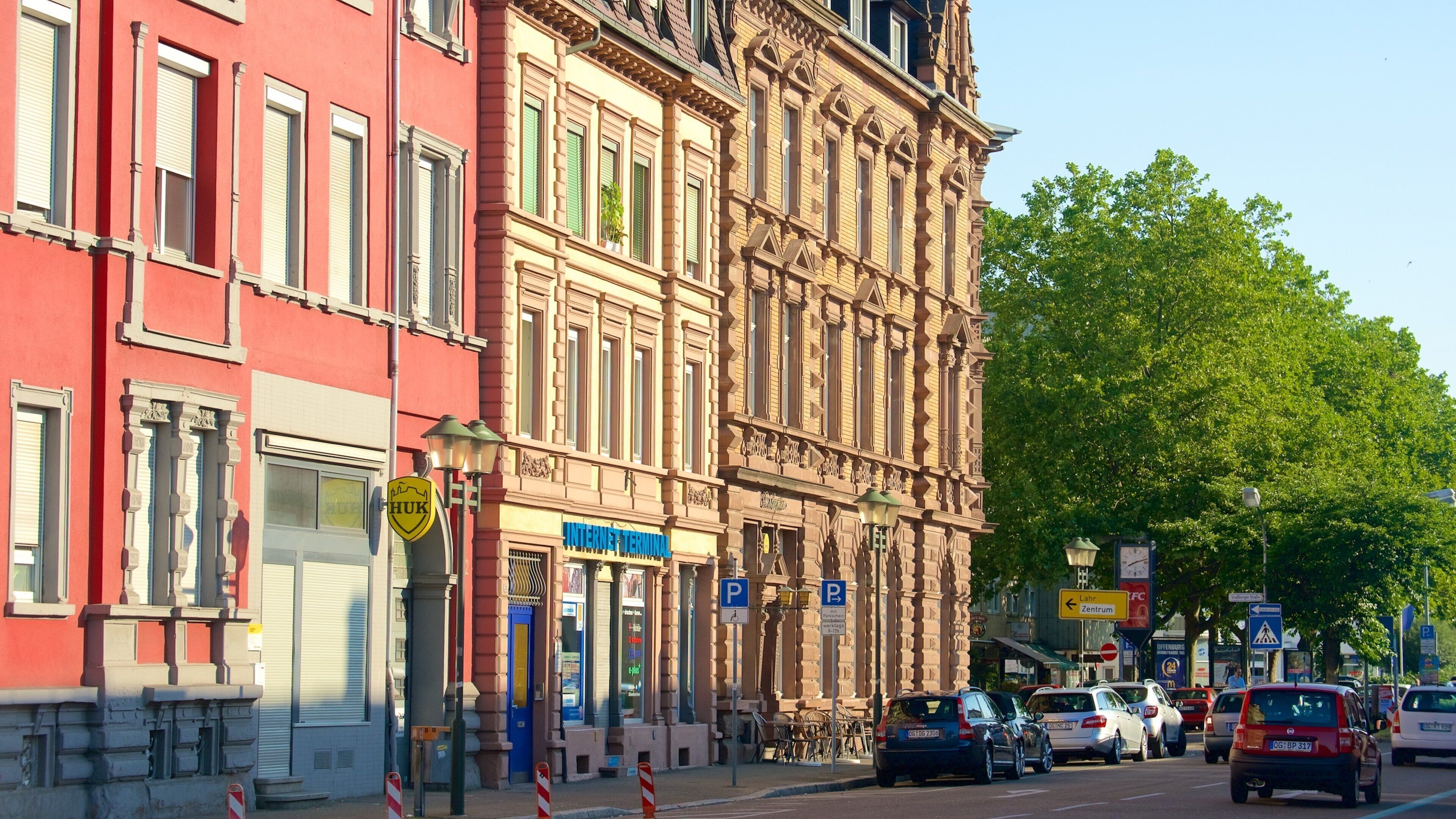 A street with historic buildings, a sign for 'Internettelterminal', and parked cars.