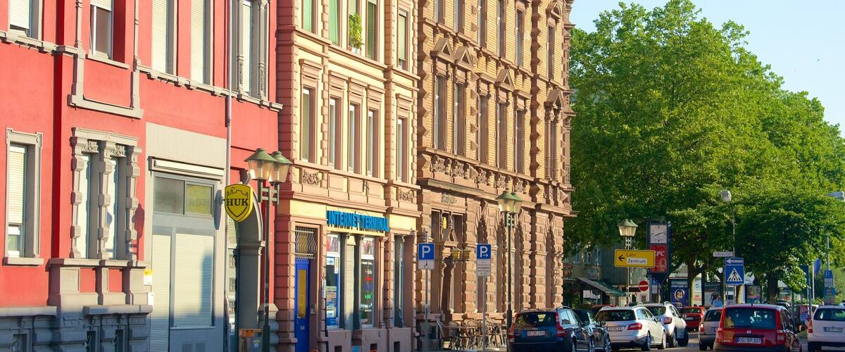 A street with historic buildings, a sign for 'Internettelterminal', and parked cars.