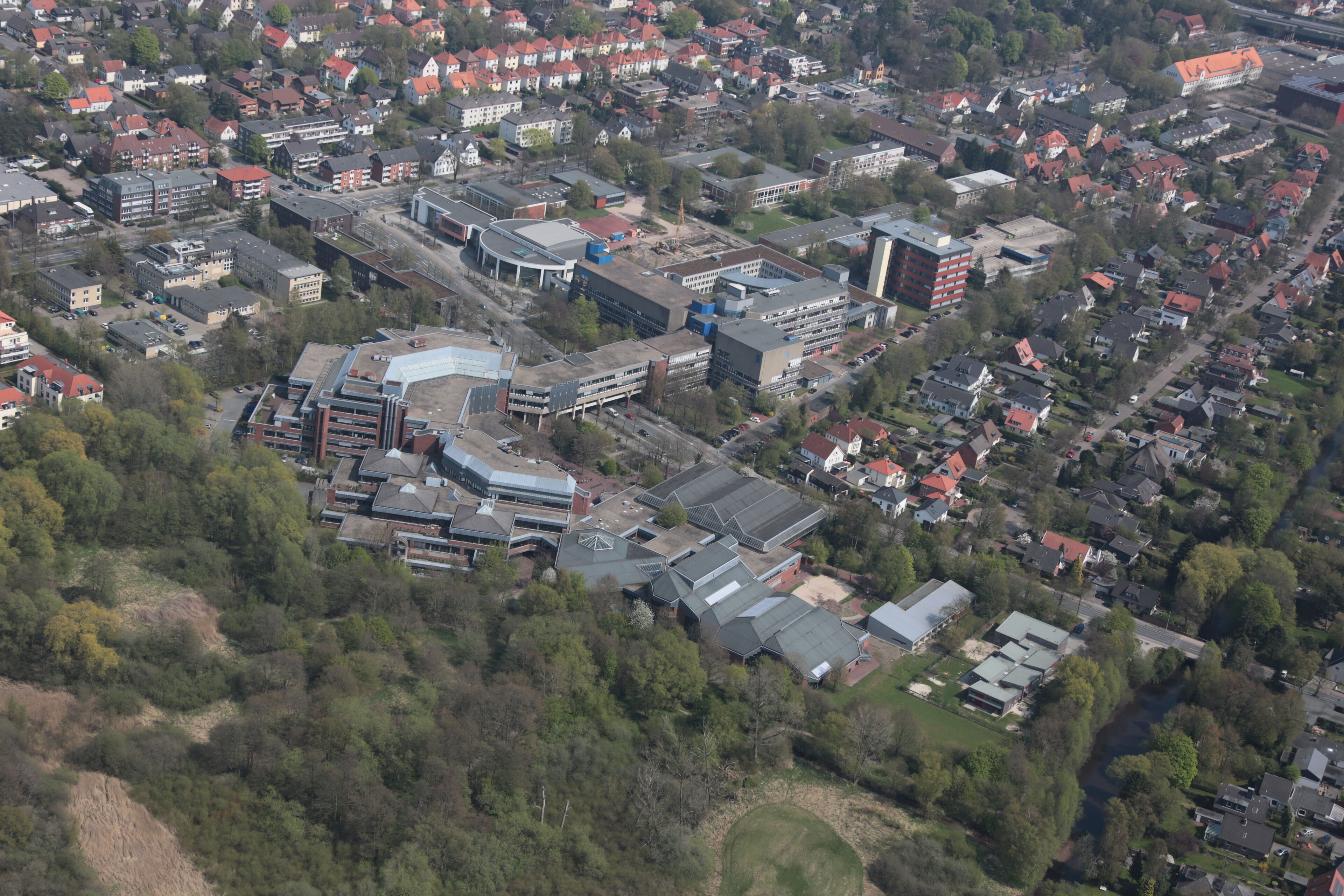 An aerial view of a town with residential houses, commercial buildings, and green spaces.