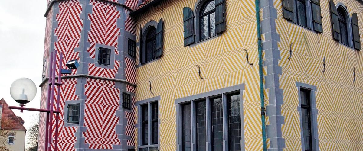 A colorful building with a tower and patterned facade.
