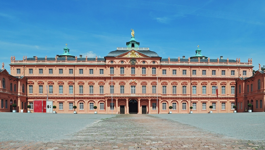A large, ornate building with a central dome and statues on the roof.