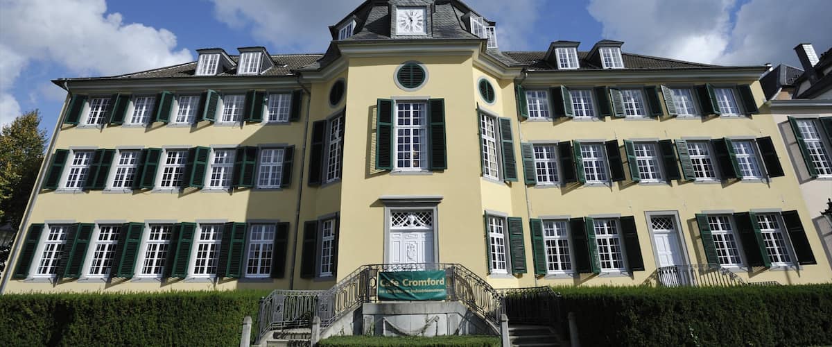 A large yellow building with green shutters and a clock tower.