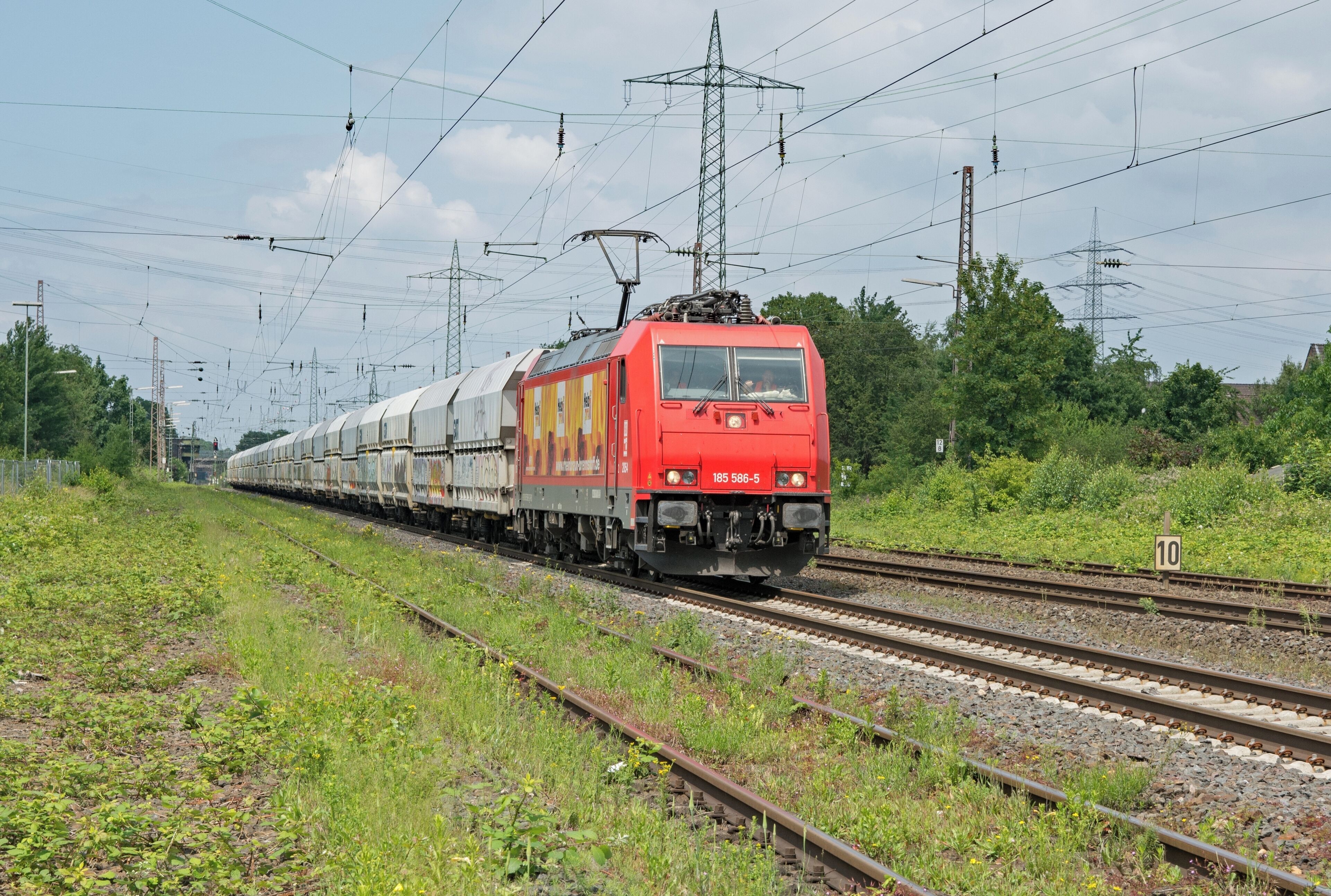 RheinCargo 185 586-5 in Ratingen-Lintorf; Masten der Bahnstromleitung 449.