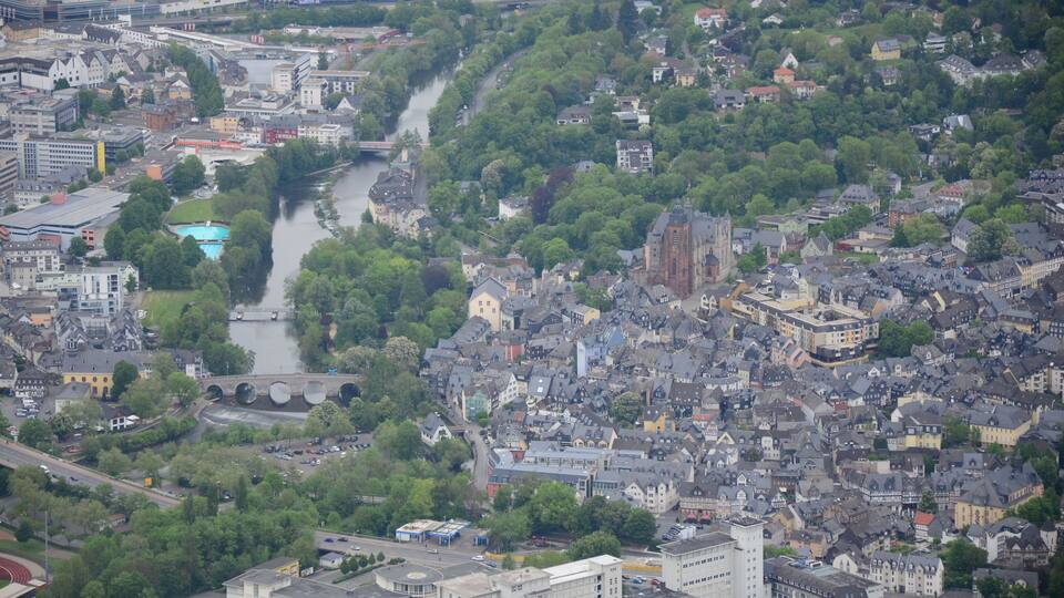 A river winding through a densely built urban area with historic buildings and modern structures.