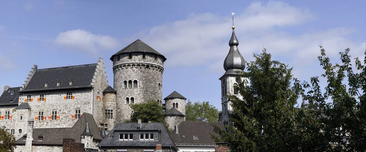 A historic stone castle with multiple towers and a church.