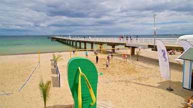 A beach volleyball court with a pier in the background.