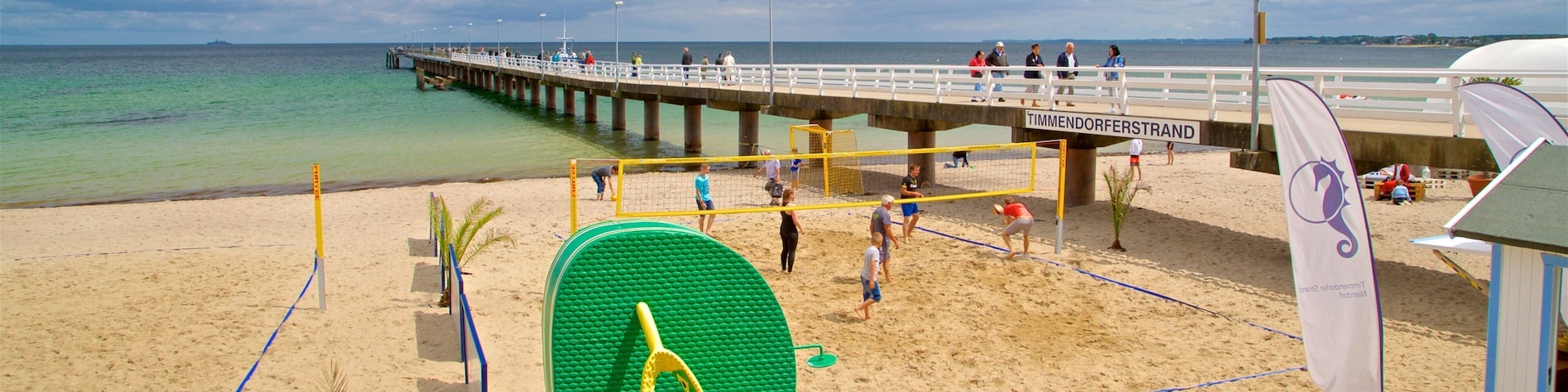 Timmendorfer Strand featuring a sandy beach and general coastal views as well as a small group of people