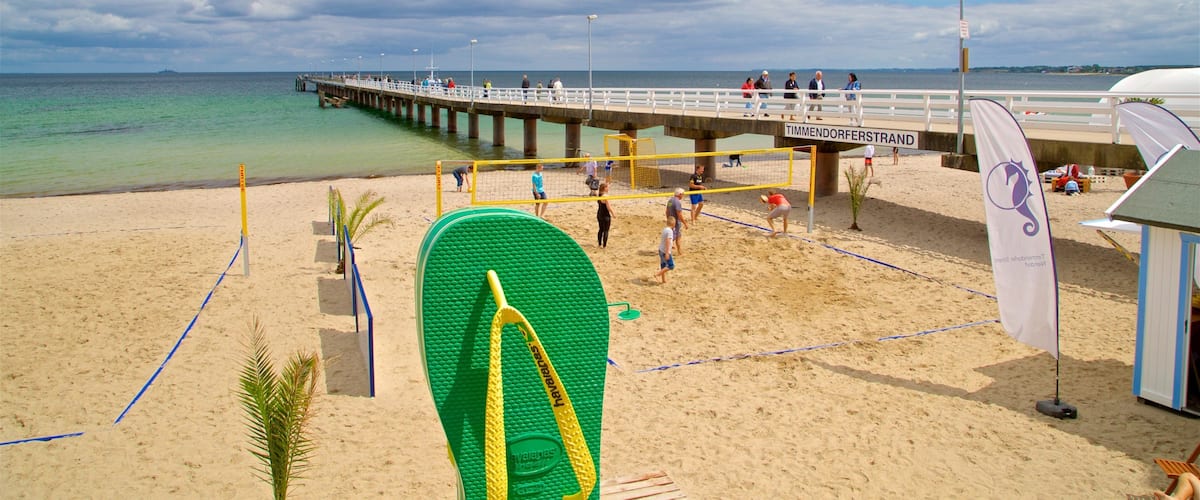 Timmendorfer Strand featuring a sandy beach and general coastal views as well as a small group of people
