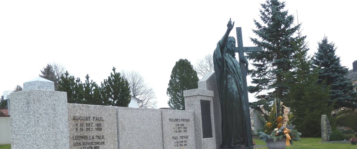 A cemetery with gravestones and a statue.